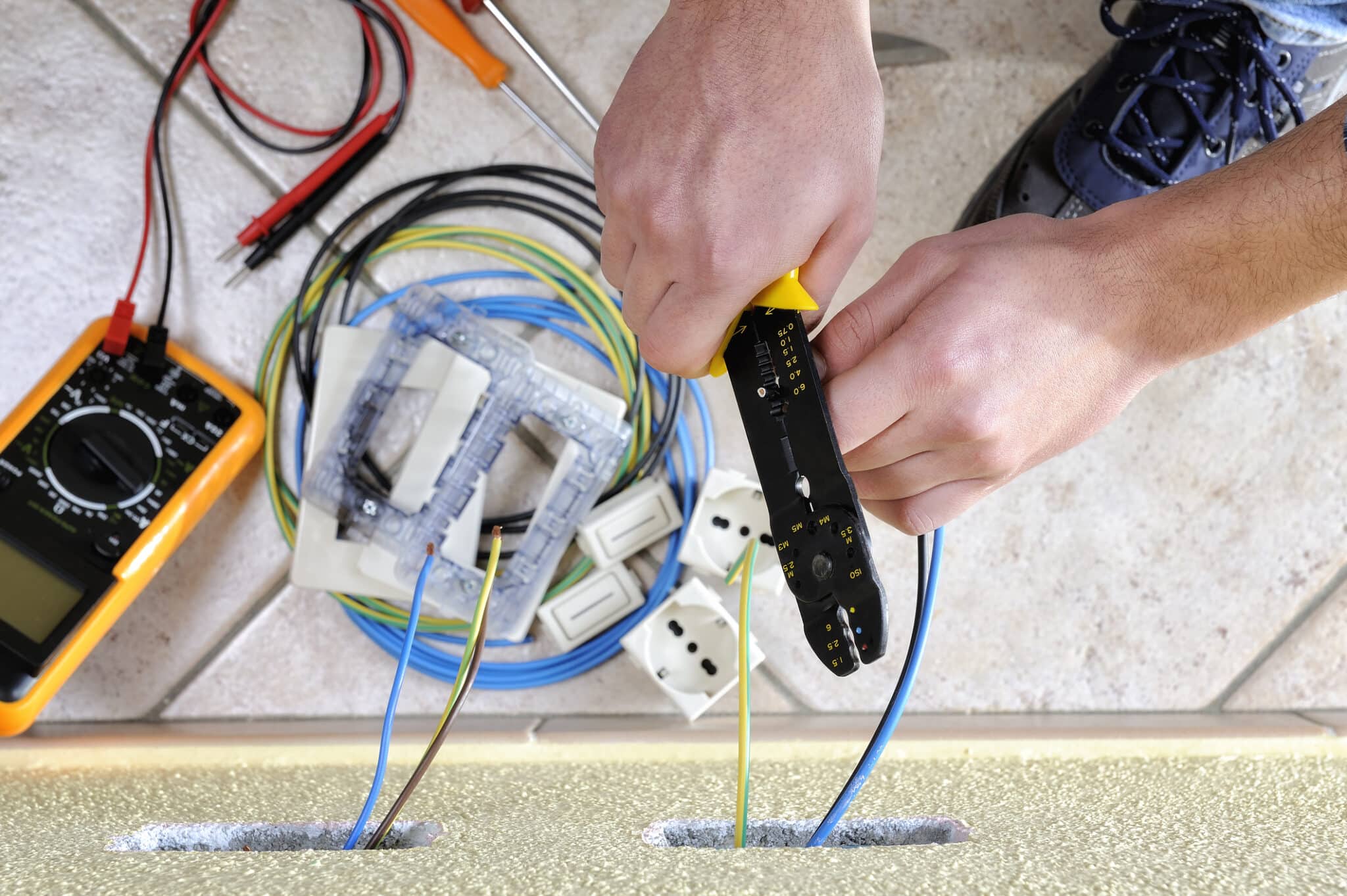 In electrical remodeling, an electrician technician utilizes a wire stripper during a residential electrical installation by Mister Sparky of Charleston