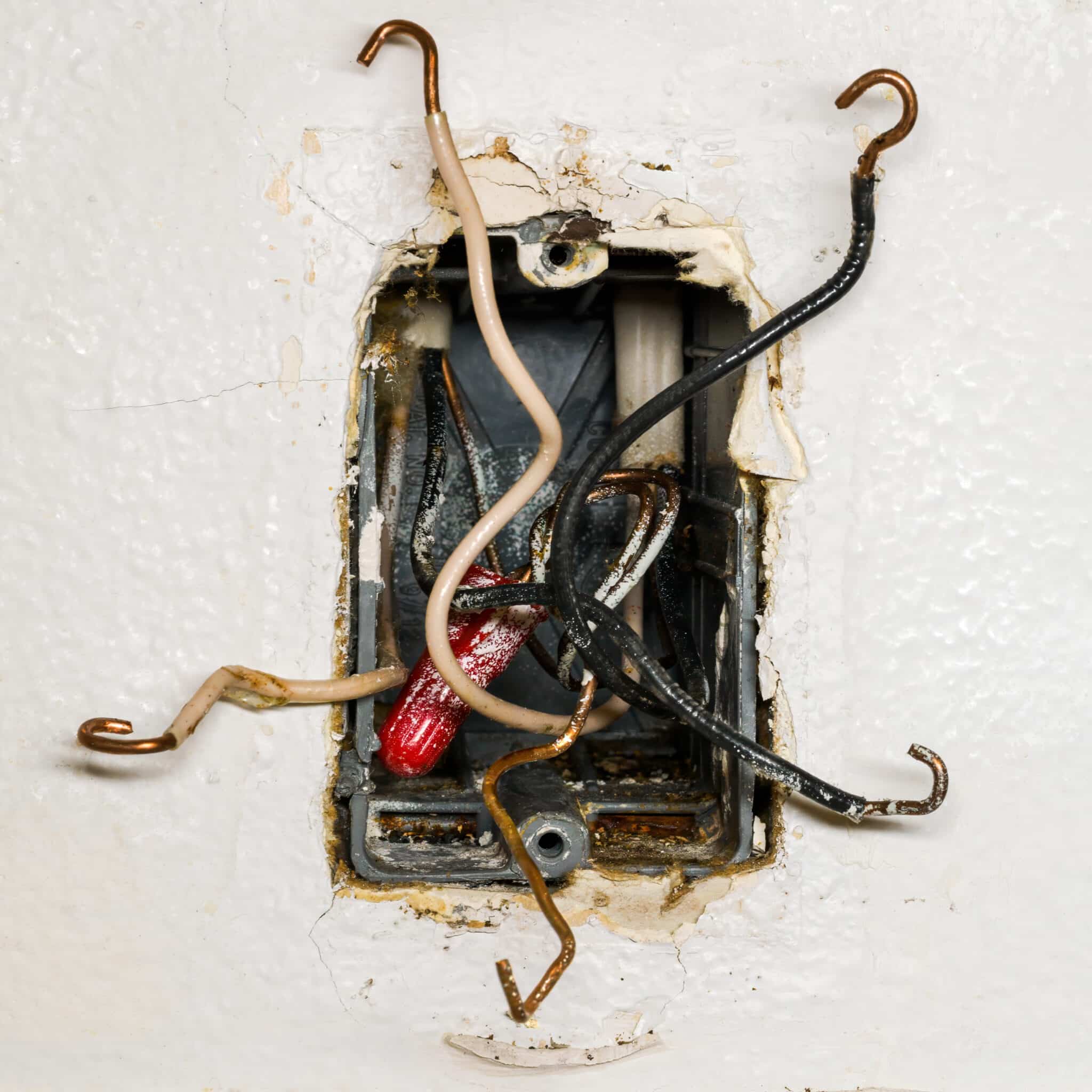 An old outlet box with 110-volt wires connected, illustrating common electrical problems.